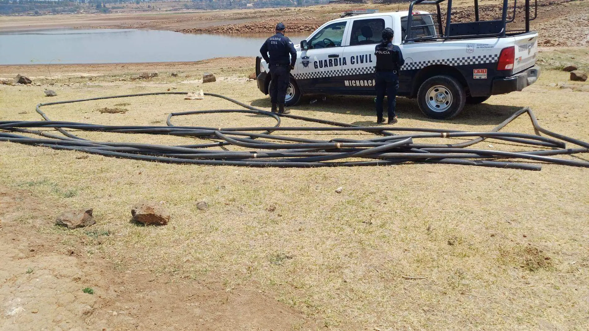 Elementos de la Guardia Civil y manguera de toma ilegal de agua